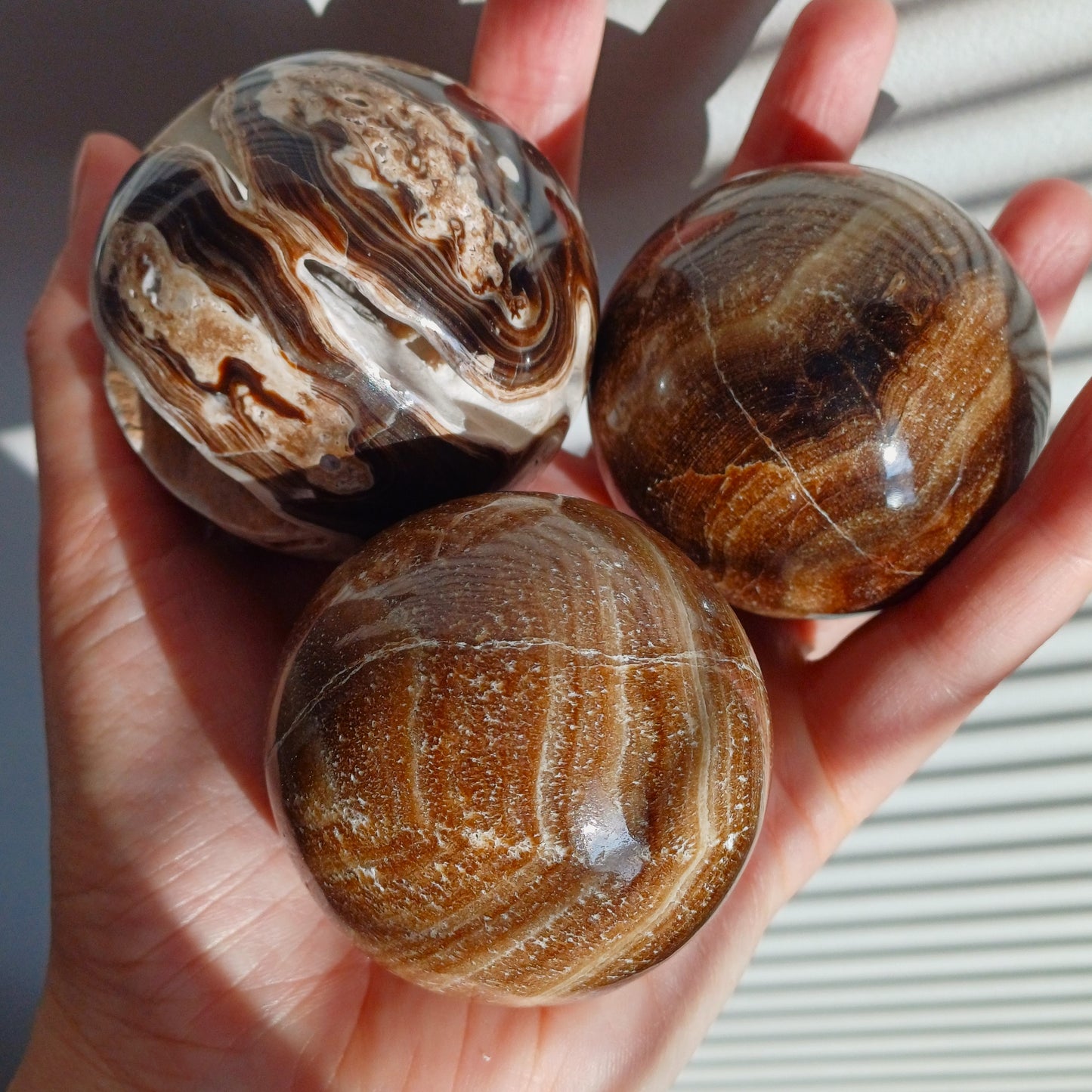 suklaakalsiitti pallo pyöreä ruskea cocolate calsite kolme kappaletta auringon paiste kämmenellä